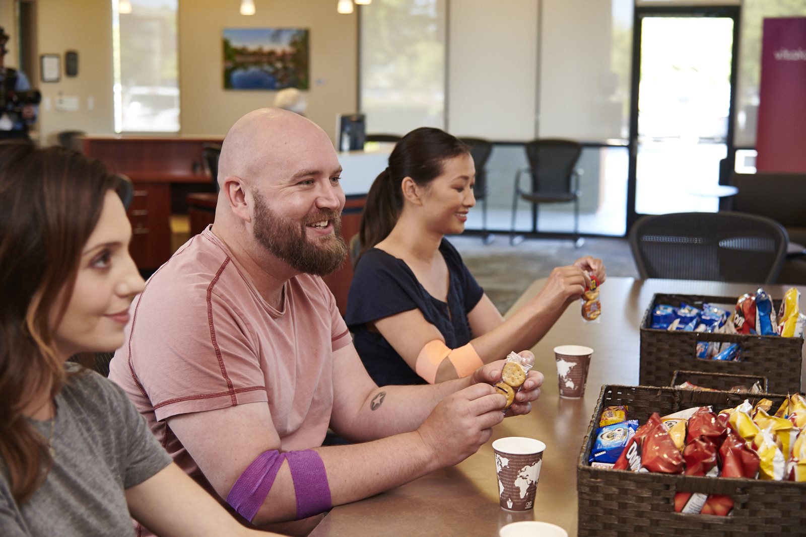 Phlebotomist Smiling next to donor in a chair