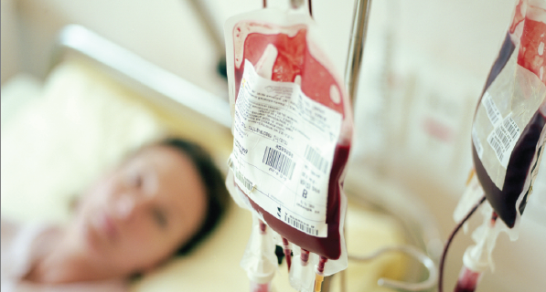 Blood donation bag with patient laying on bed