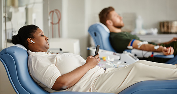 Women on hospital bed looking at phone