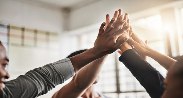 People joining hands together in the air