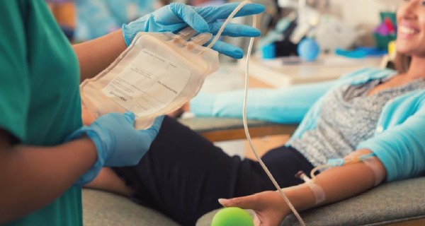 Medical professional holding blood donation bag