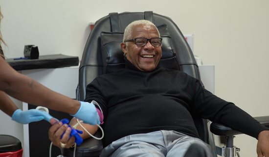 Blood donor in chair donating blood