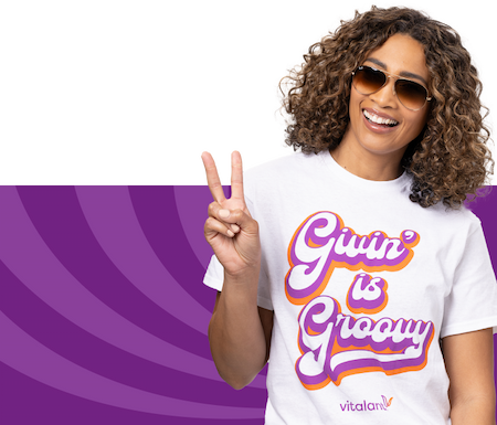 Person holding up peace sign and wearing groovy shirt